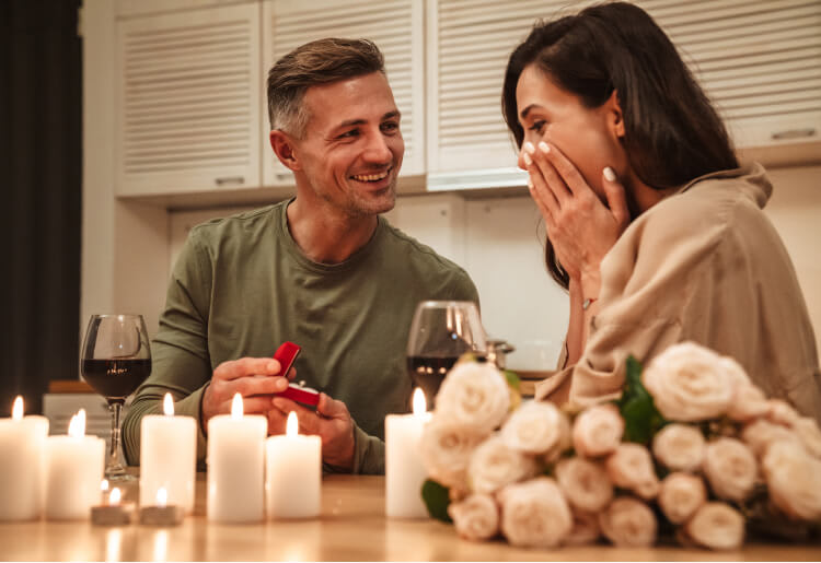 Good looking man proposes to his girlfriend with a ring
